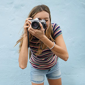Girl holding a camera and taking a picture